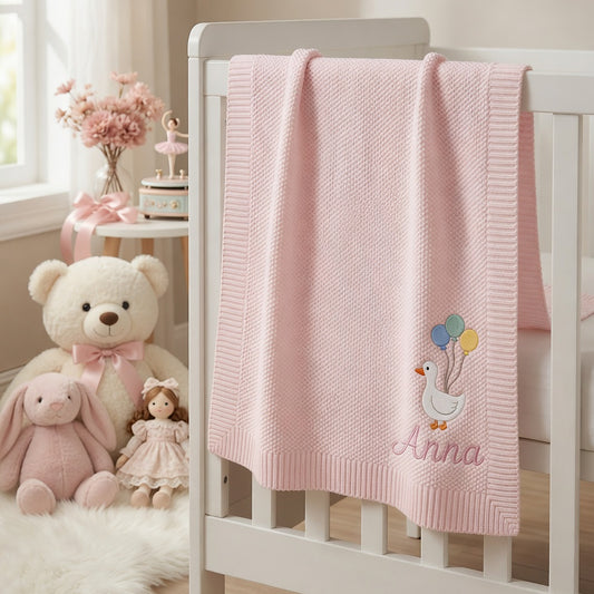 Pink Anna Blanket Draped Over White Nursery Crib