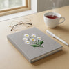 Gray Daisy Notebook Styled With Tea Glasses And Pen