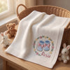 White Rosie Booties Blanket Draped Beside Plush Bunnies