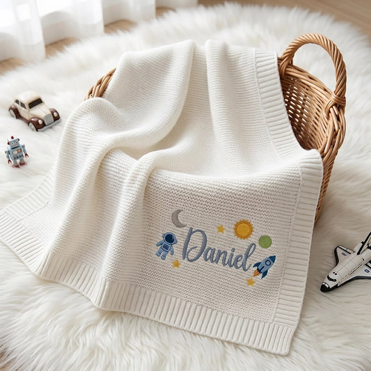 White Daniel Space Blanket Draped Over Wicker Nursery Basket