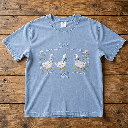 Blue Geese Embroidered Shirt Displayed On Rustic Wood