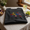 Folded Black Daily Vitamin Tee Surrounded By Fresh Fruit