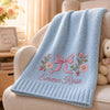 Light blue baby blanket with pink bow and flowers