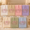Seven colorful embroidered baby blankets with personalized bow designs