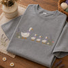 Folded Grey Goose Graphic Tee Surrounded By Craft Supplies