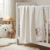 White Bunny Baby Blanket Draped Over Crib