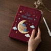Maroon Embroidered Notebook Held Beside White Pen