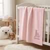 Pink Personalized Bunny Blanket Hanging Over White Nursery Crib