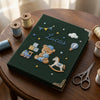 Dark Green Treasure Notebook Styled Beside Threads And Scissors