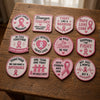 Twelve Breast Cancer Support Patches Displayed On Wooden Table