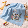 Light Blue Floral Swan Blanket Draped Over Wicker Basket